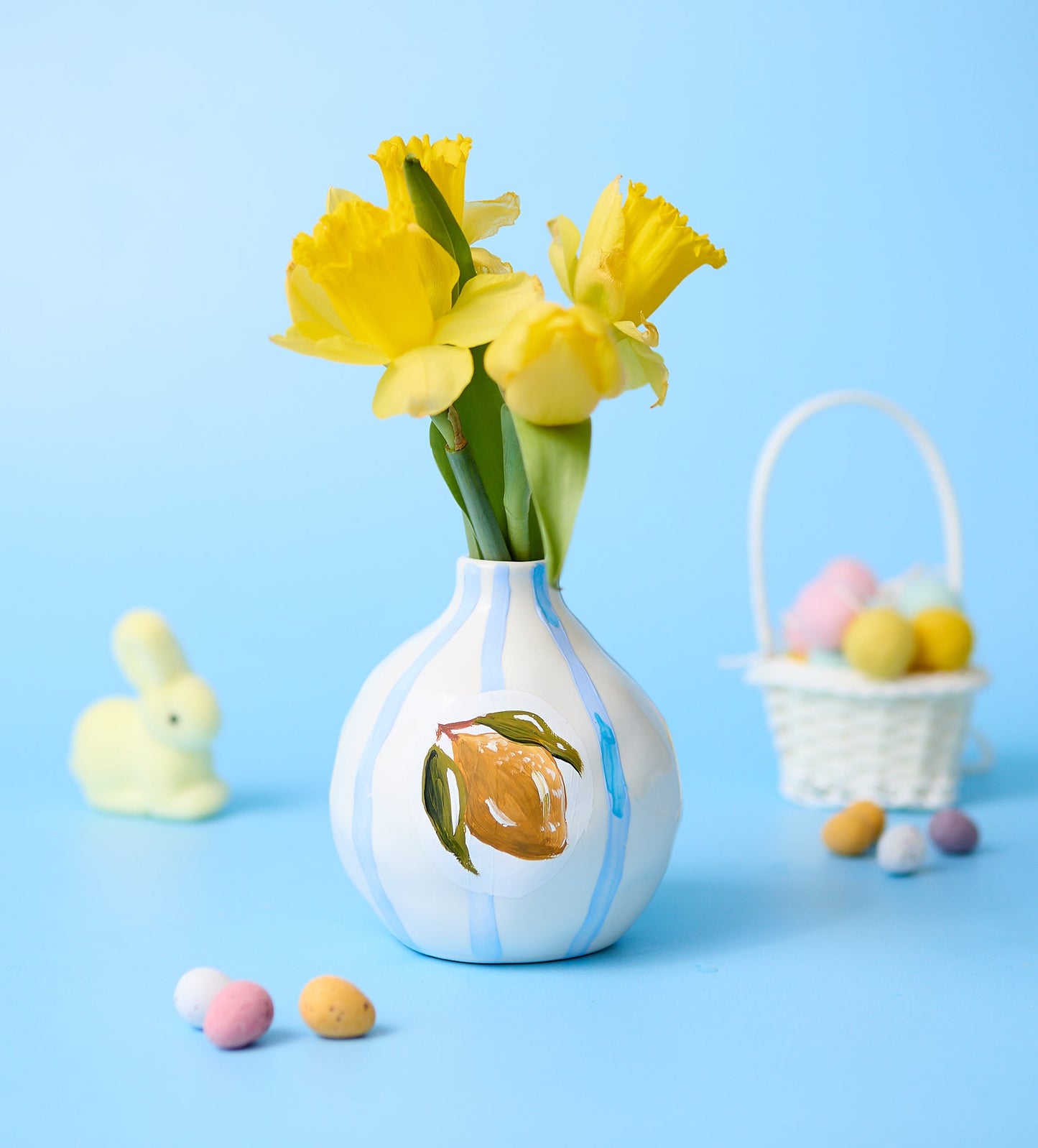 Home pottery and candle making kit with pastel paints, tools, and cactus-shaped candle holder on pink background.