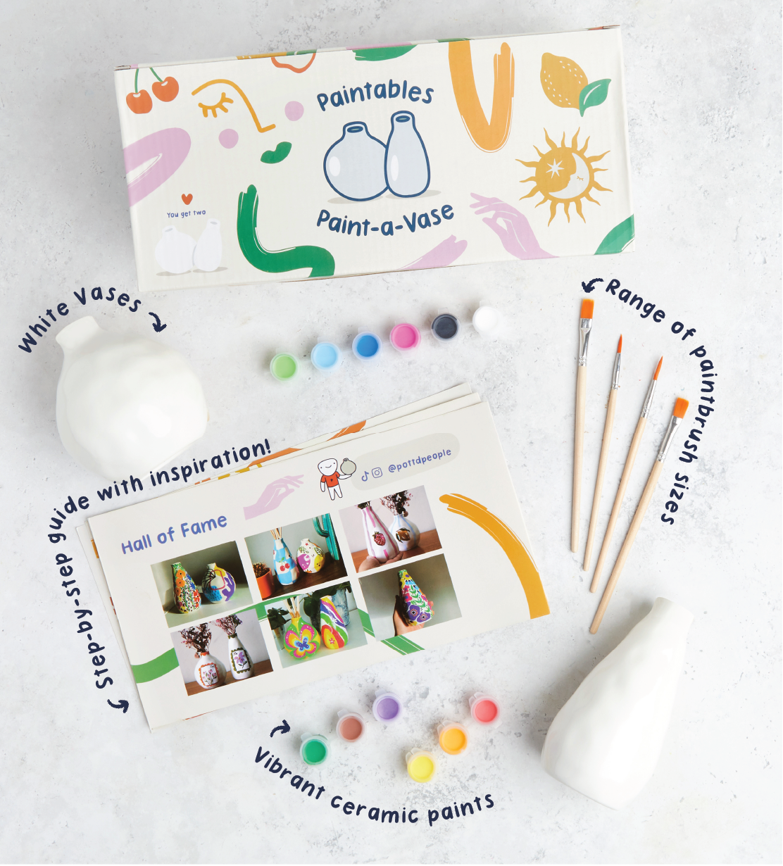 Hand painting white ceramic mug with pink and red heart pattern and "I Love You" text on a pink tabletop setting.