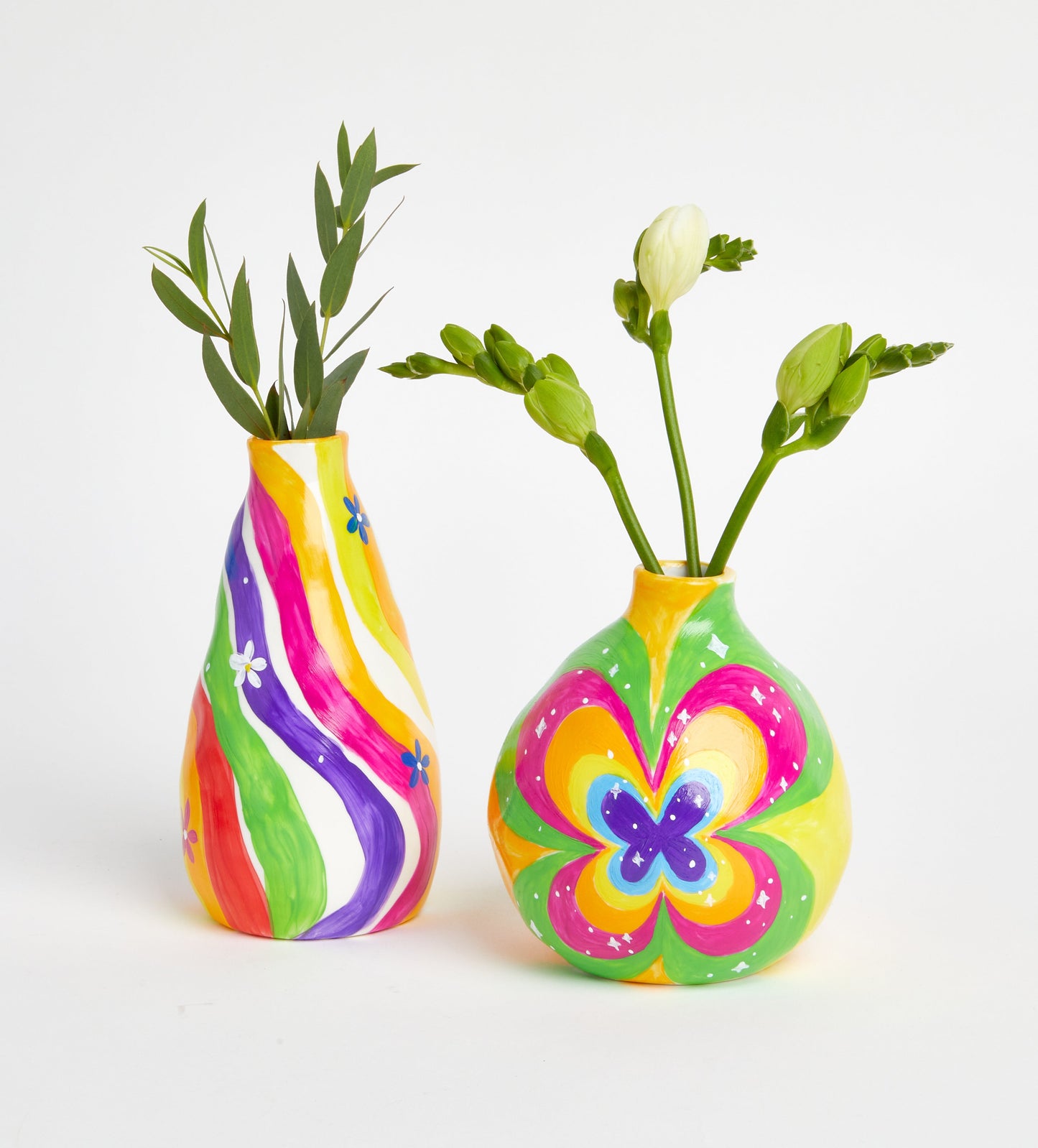 Gift box labeled "Date Night Candle Kit" with gold ribbon, cartoon design, held above pink tablecloth with pink flowers.